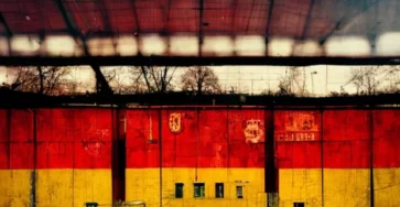 фотография стадиона для футбола с фоном красно-желтой стены
